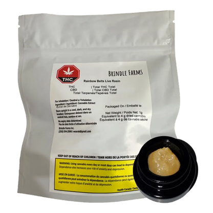 White pouch standing upright with a label and a small open black jar of pale yellow concentrate in front, showing "Rainbow Belts Live Rosin" by Brindle Farms.