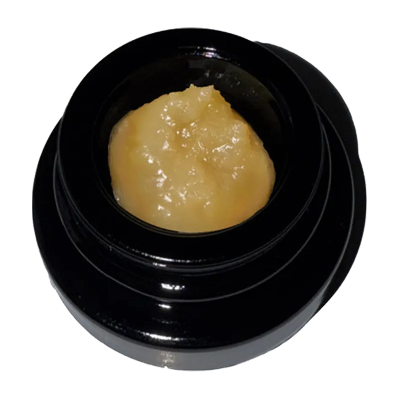 Top-down view of a glossy black jar holding golden concentrate labeled Rainbow Belts Live Rosin in the center.