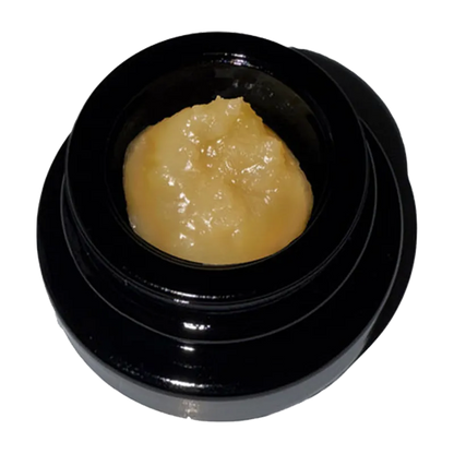 Top-down view of a glossy black jar holding golden concentrate labeled Rainbow Belts Live Rosin in the center.
