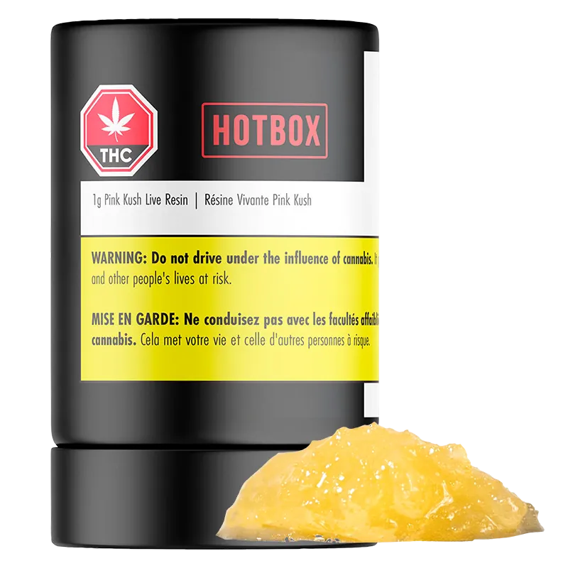 Front-facing shot of a black Hotbox Pink Kush Live Resin container with a yellow warning label and a glossy amber dab of concentrate in front.