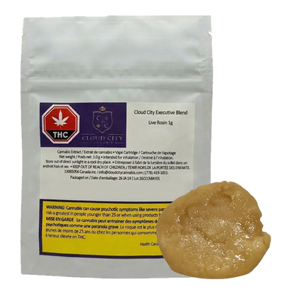 Front-facing shot of a white pouch and amber dab showing the 2026 Executive Blend Live Rosin label and glossy extract in the lower right.