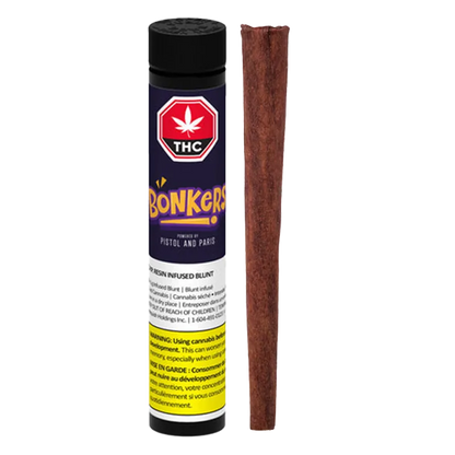Straight-on view of an upright O.P.P. Resin Infused Blunt PR 1 x 1 g tube with purple label beside a single brown blunt.