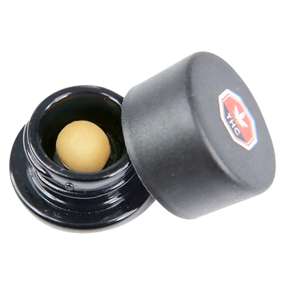 Close angled view of an open black jar revealing a smooth tan sphere inside, labeled as Code Blue Whipped Diamonds.