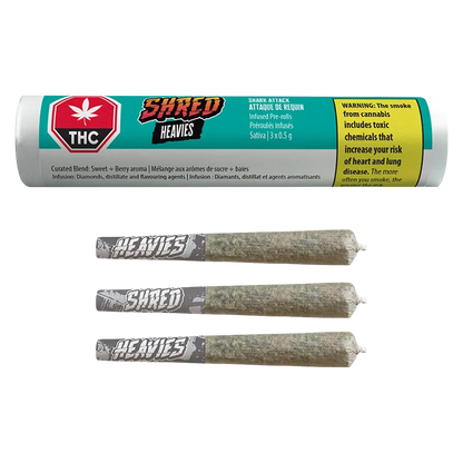 Top-down view of three rolled joints with gray "HEAVIES" tips beneath a turquoise tube labeled Shark Attack Heavies Infused PR 3 x 0.5 g.