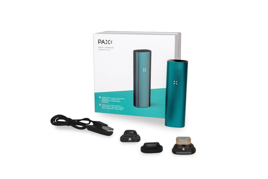 A slightly angled studio shot of the teal Pax 3 - Complete Kit, including accessories, displayed on a dark surface.