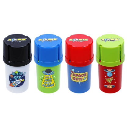 Row of four colorful Atomik Grind & Stash containers photographed front-on, each with a different bright cap and space-themed sticker.