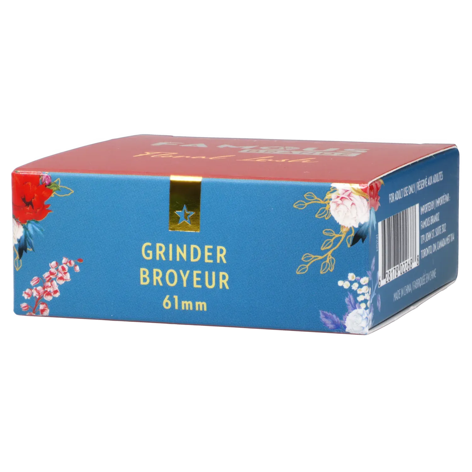 Angled front view of the Famous Design Floral Lush Aluminum 2 Stage Grinder - Teal and Gold box showing teal floral sides, a red top, gold star accent, and a visible barcode.
