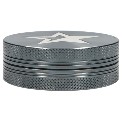 Low-angle close-up of the Famous X Chrome 2 pc Grinder - Gray-55mm showing its textured knurled sides, stacked ridges, and white star graphic on the top.