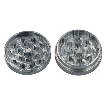 A top-down view of the two-piece Famous X Chrome grinder in gray, showcasing its textured metallic finish and circular design.