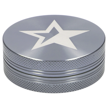 Top-down angled view of the Famous X - Crystal 2 pc Grinder-Silver-55mm showing its silver lid with a recessed white star and textured knurled sides.