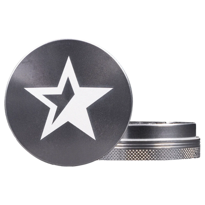 Close-up front view of the Famous X - Crystal 2 pc Grinder-Silver-55mm showing a black lid with a white star motif and the textured silver grinder base.
