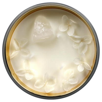 Top-down view of the Queen of Bud: Clarity Ritual Box – Candle, Zippo, and Crystal showing a creamy white candle surface with a central clear crystal and delicate pressed white flowers.