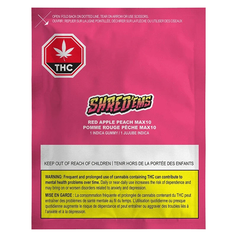 Front-facing shot of the bright pink packet labeled "Red Apple Peach Gummies" by Shred'ems with THC symbol and warning box at the bottom.