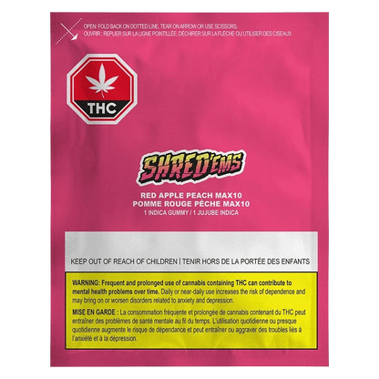 Front-facing shot of the bright pink packet labeled "Red Apple Peach Gummies" by Shred'ems with THC symbol and warning box at the bottom.
