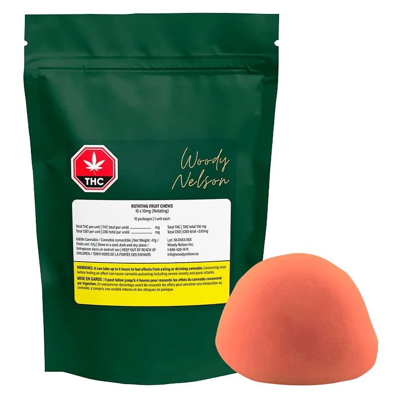 Front view of a green pouch labeled Woody Nelson Rotating Fruit Chews Gummies with a red THC symbol and a single orange half-sphere candy beside it