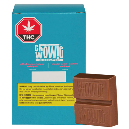 Three-quarter view of a stacked milk chocolate bar in front of a teal box labeled Chwowig Chocolates Balanced Milk Chocolate.