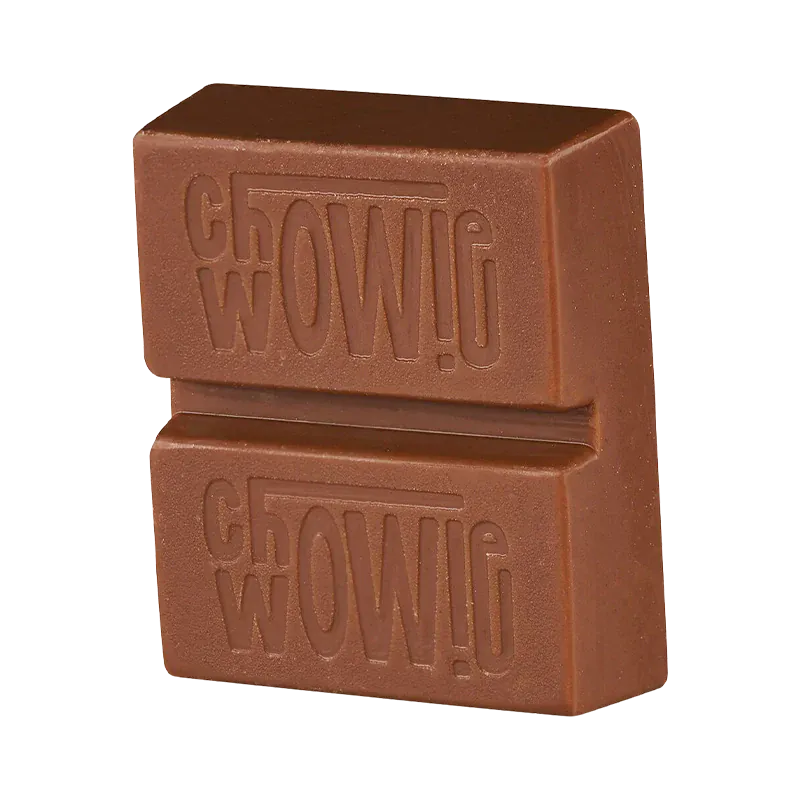 Close-up three-quarter view of a stacked chocolate piece embossed with the Balanced Milk Chocolate name, shown against a white background.