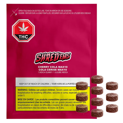 Front-facing shot of a bright magenta package labeled Shred'ems Cherry Cola Gummies with sugared brown round gummies shown stacked to the right.