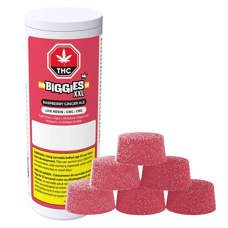 Angled view of a white canister labeled Biggies XXL with raspberry-red "Raspberry Ginger Ale Live Resin Gummies" branding beside a pyramid of six sugar-coated pink gumdrop-style gummies.