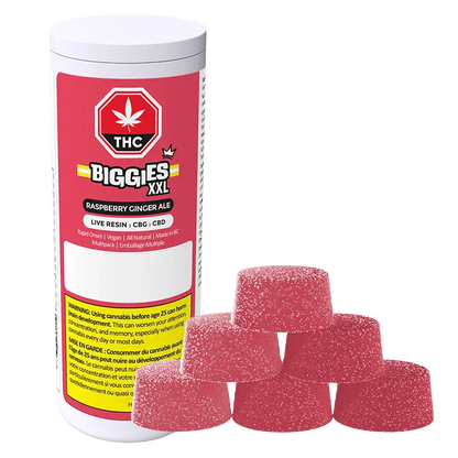 Angled view of a white canister labeled Biggies XXL with raspberry-red "Raspberry Ginger Ale Live Resin Gummies" branding beside a pyramid of six sugar-coated pink gumdrop-style gummies.