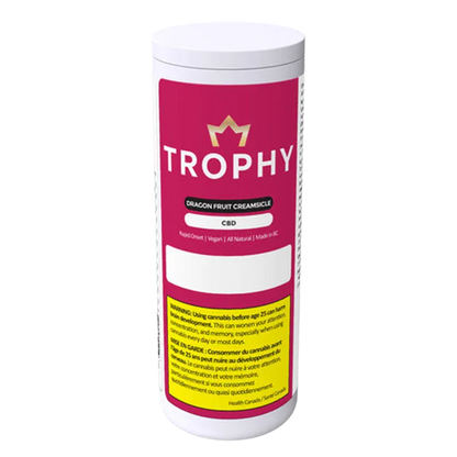 Front-facing shot of a white canister labeled "TROPHY Dragon Fruit Creamsicle Gummies" with a magenta label, gold crown logo, and safety text.