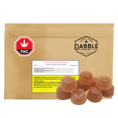 Rounded pile of sugar-coated gummies in front of a tan pouch labeled Dabble Cannabis Co. Strawberry Jam Live Rosin Gummies.