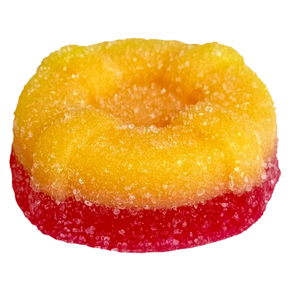 Close-up of a two-toned sugar-coated gummy in yellow over red, photographed from slightly above, showing texture and a shallow center, Ratio'd Tropic Boost Gummies