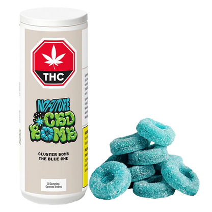 White cylindrical container labeled "CBD Cluster Bomb - The Blue One Gummies" stands to the left of a small pile of sugar-coated blue ring gummies.