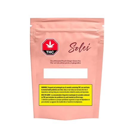 Front-facing shot of the pink Solei Decaffeinated Peach Ginger Green Tea Bags pouch with a THC stop-sign logo and yellow warning box.
