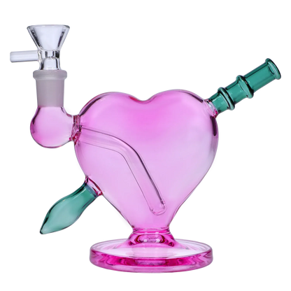 Angled close-up of the pink Heart Bong w/Bowl + Banger showing its heart-shaped chamber, green mouthpiece, and glass bowl connection.