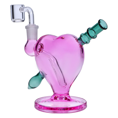 Angled close-up of the pink Heart Bong w/Bowl + Banger showing its heart-shaped chamber, teal mouthpiece, and clear glass banger.