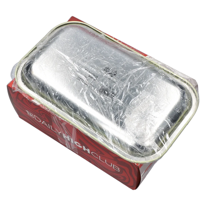 Angled top view of a silver tray wrapped in clear plastic resting on a red DHC - Mystery Box - Spaced Out cardboard sleeve.