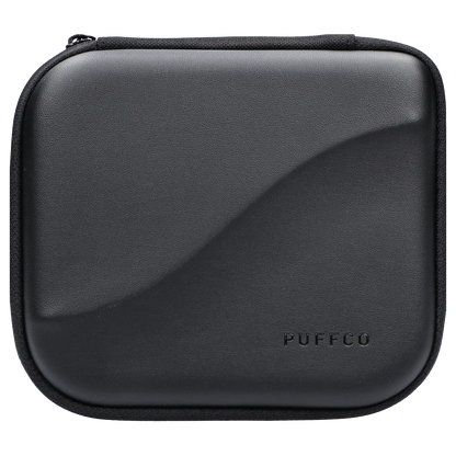 Top-down close-up of the black Proxy – Desert travel case showing its textured shell, zipper edge, and embossed PUFFCO logo.