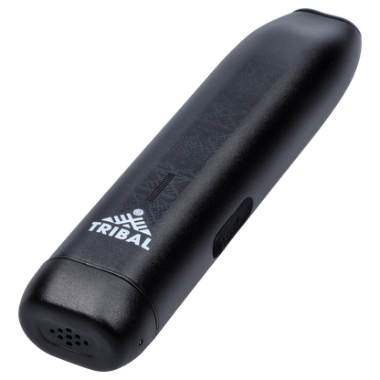 Angled close-up of the black Tribal Aerolith Dry Herb Vaporizer showing its textured top surface, white TRIBAL logo, and side power button.