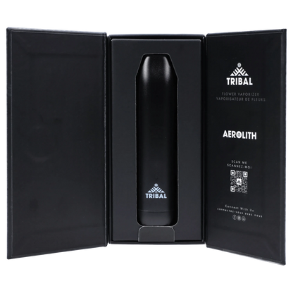 Center view of the black Tribal Aerolith Dry Herb Vaporizer nestled upright in its open black presentation box with printed logo and QR code on the right panel.