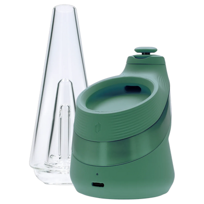 Close-up angled view of the green Puffco New Peak - Pine device next to its clear glass cone mouthpiece.