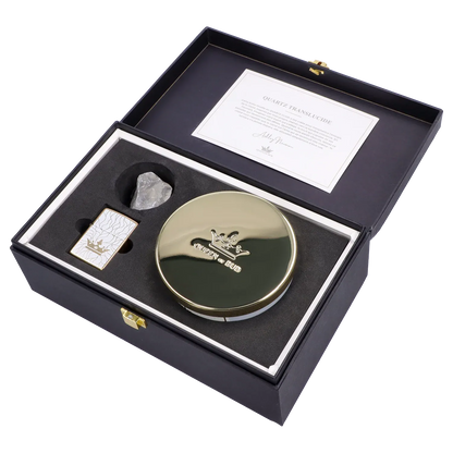 Angled top-down view of the Queen of Bud: Clarity Ritual Box – Candle, Zippo, and Crystal neatly arranged in a black foam-lined box with a gold-lidded round candle, white patterned Zippo, and translucent crystal.