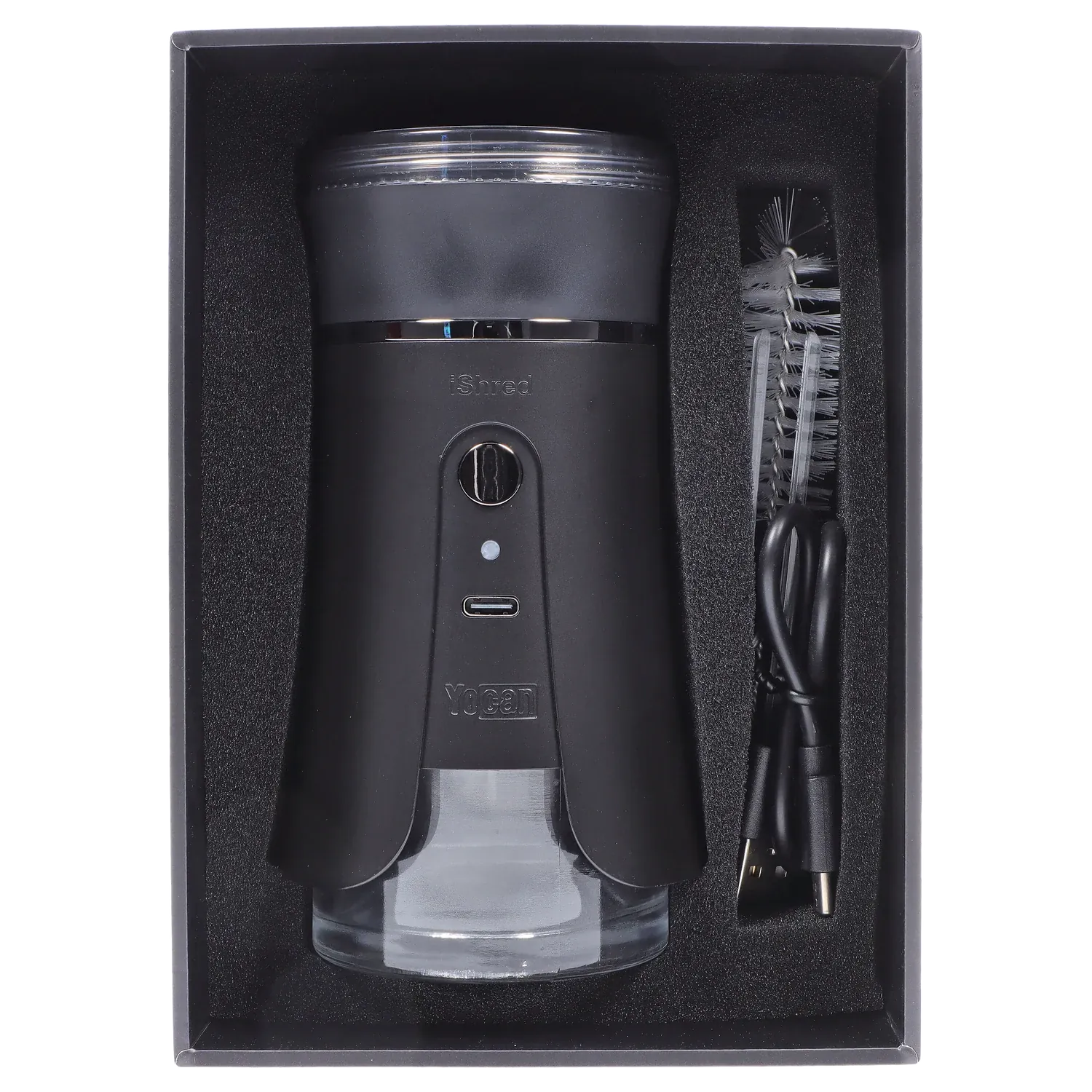 Top-down view of the black Yocan iShred Electronic Grinder – Black nestled in foam packaging with a USB cable and cleaning brush beside it.
