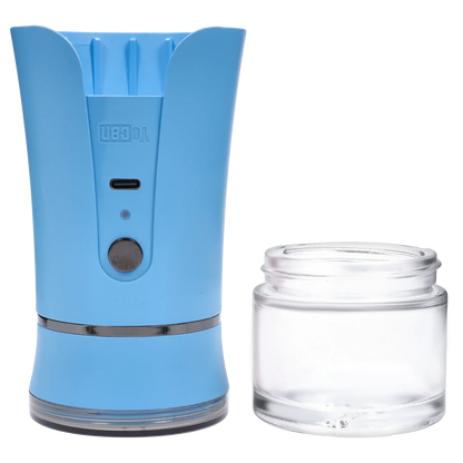 Close-up front view of the blue Yocan iShred Electronic Grinder showing its USB-C port, round button, and a clear glass jar beside it.