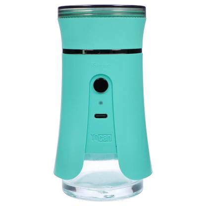 Close-up front view of the green Yocan iShred Electronic Grinder showing its circular power button, USB-C port, and clear lower chamber.