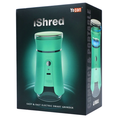 Angled front view of the green Yocan iShred Electronic Grinder on its dark branded packaging, lit with a soft teal glow.