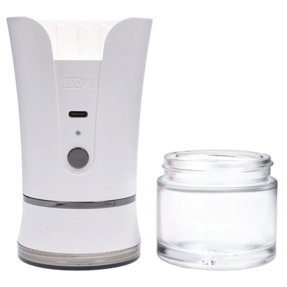 Left-front close-up of the ivory Yocan iShred Electronic Grinder showing its curved top, front button and USB-C port next to a clear glass collection jar.