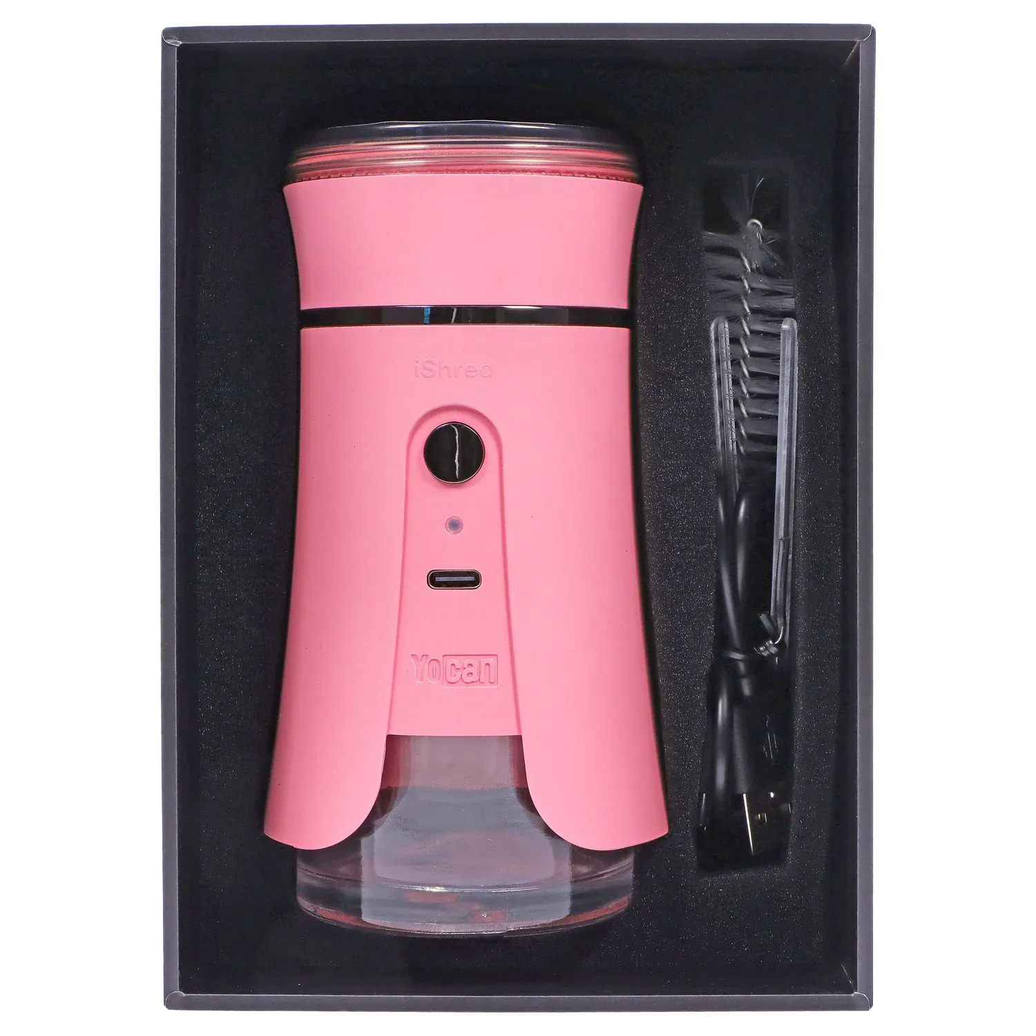 Top-down view of the pink Yocan iShred Electronic Grinder nestled in black foam with its USB cable and brush to the right.