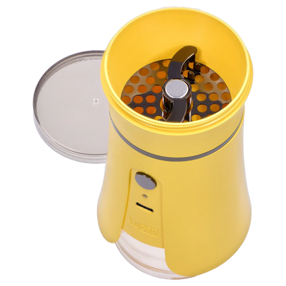 Top-down close-up of the open Yocan iShred Electronic Grinder – Yellow showing its yellow bowl, metal grinding plate and clear lid beside it.