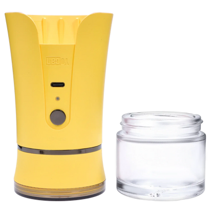 Close front view of the yellow Yocan iShred Electronic Grinder next to its clear collection jar on a white background.