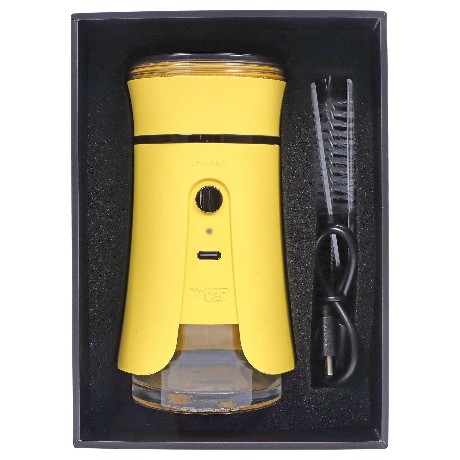 Top-down view of the bright yellow Yocan iShred Electronic Grinder – Yellow seated in black foam packaging alongside a cleaning brush and USB cable.