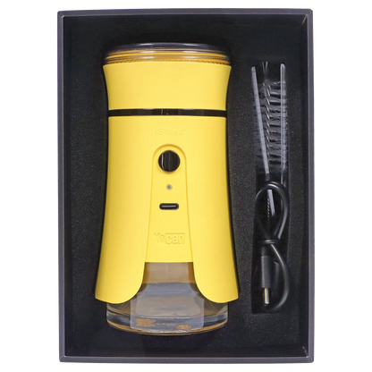 Top-down view of the bright yellow Yocan iShred Electronic Grinder – Yellow seated in black foam packaging alongside a cleaning brush and USB cable.