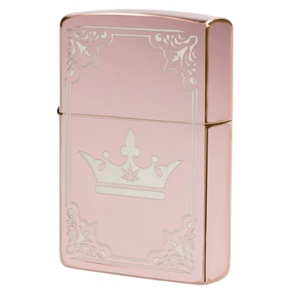 Angled close-up of the Queen of Bud Zippo Rose Quartz Filigree showing its pink metallic case, engraved crown motif and decorative filigree border.