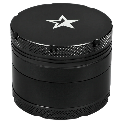 Close-up top-down view of the Famous X 4 pc Grinder -Black - 50mm showing its matte black lid with a silver star logo and textured knurled edges.