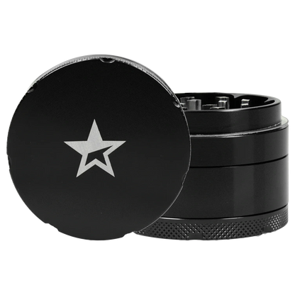 Close-up three-quarter view of the Famous X 4 pc Grinder -Black - 50mm showing the black top with a silver star logo and textured knurled base.
